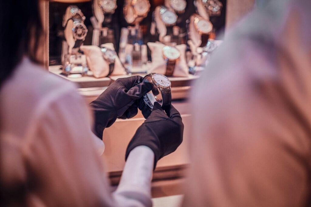 Luxury vintage watch being displayed by a seller wearing black gloves in a high-end boutique. The perfect investment piece for collectors and watch enthusiasts.